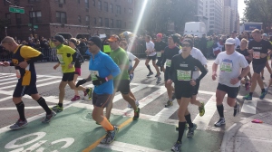 Runners in the 2013 New York Marathon turn on 1st Avenue on Manhattan, while thousands of people are cheering them. (Picture by Koen Blanquart)